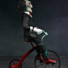 NECAOnline.com | Saw - 12" Action Figure with Sound - Puppet on Tricycle